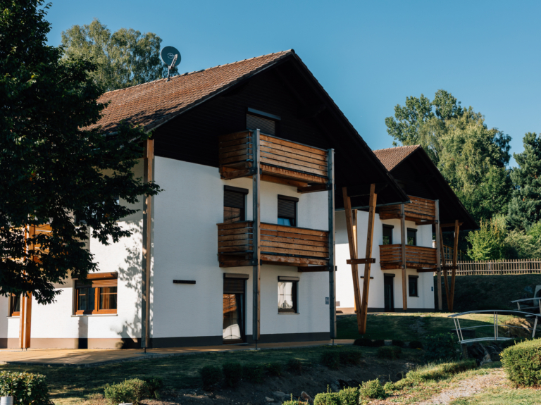 Haus Horizon: Mehrfamilienhaus mit Holzbalkonen und Fenstern in Holzoptik